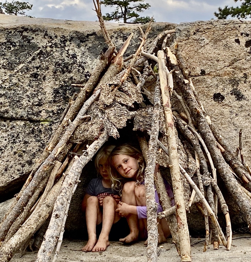 picture of kids in a wilderness shelter they built